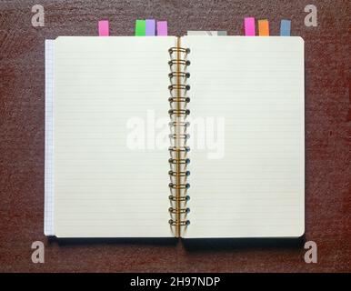 Open spiral bound notebook with blank pages and colorful bookmarkers Stock Photo