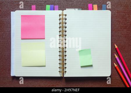 Open spiral bound notebook with  blank pages and post-it notes. Flat lay, copy space Stock Photo
