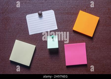 Colorful post it notes on dark brown board. Copy space Stock Photo