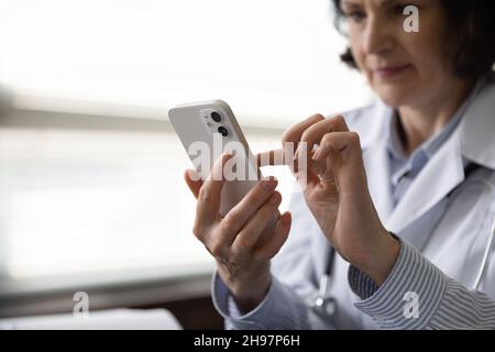 Close up of smartphone in female doctor, medic physician hand Stock Photo