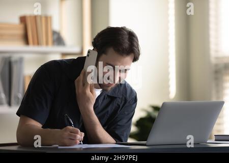 Happy male office worker, employee working on telephone in office Stock Photo