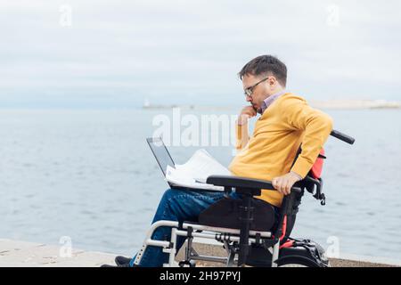 a man with a disability in a disabled working business remotely Stock Photo