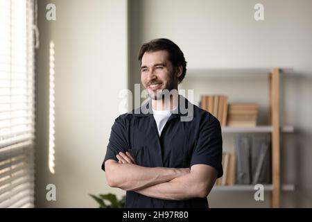Happy thoughtful entrepreneur, business man standing with folded arms Stock Photo