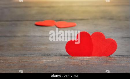 couple of hearts on wooden background. red hearts are together in a cracked wooden surface. Stock Photo