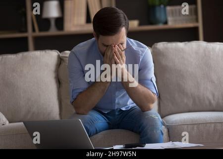 Frustrated young man tired of domestic paperwork Stock Photo