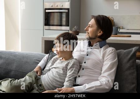 Happy dreamy multigenerational family resting on couch. Stock Photo