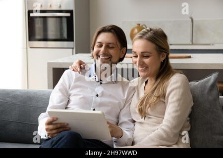 Happy bonding couple using digital tablet at home. Stock Photo