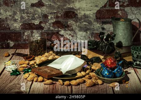 Still life with chocolates, almonds, chocolate and spices on wooden table Stock Photo