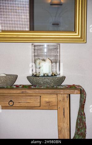 Details of a rustic interior with small table, mirror and various decorations. Stock Photo