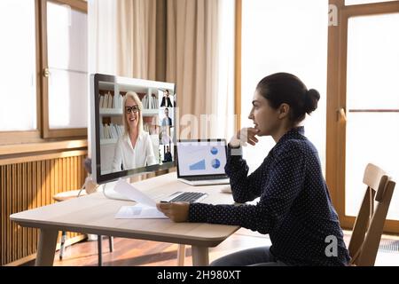 Focused Indian young employee talking to boss and business team Stock Photo