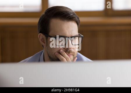 Serious male employee in glasses working at office workplace Stock Photo