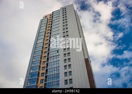 Chelyabinsk, Russia - December 2021: Modern high-rise building against the sky with clouds. Bottom up view. Stock Photo