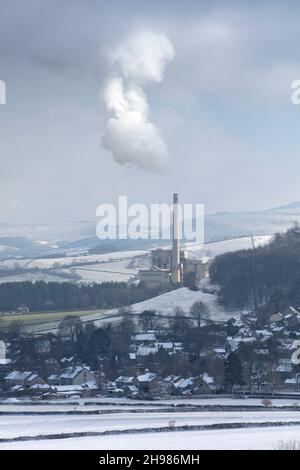 Hope Cement Works, Hope, Derbyshire, 2019. General view of the cement works in the snow, with Castleton village in the foreground and Mam Tor behind, from the north-west. Stock Photo