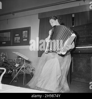 John Laing and Son Limited, Page Street, Mill Hill, Barnet, London, 27/03/1953. Miss A Hatch playing an accordion at the Sports Club annual dinner. The Sports Club annual dinner was held in the canteen at Laing's Mill Hill office. Following the dinner, entertainment included a piano accordion recital, and concluded with a sing-song. Stock Photo