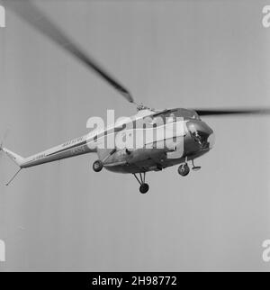 John Laing and Son Limited, Page Street, Mill Hill, Barnet, London, 30/04/1958. Looking up at Laing's Bristol Sycamore helicopter with J M Laing and a party of men on board. Laing's helicopter was used to photograph and inspect progress on their construction sites such as the London to Yorkshire Motorway (M1 Motorway). Stock Photo