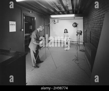 John Laing and Son Limited, Page Street, Mill Hill, Barnet, London, 11/05/1966. A photographer taking a photo of a model in the studio of the new Sports Club centre soon after the centre's opening. By 1966, membership of the Laing Sports Club had reached 2,500 throughout the country. A new Sports Club wing opened at John Laing and Son Ltd's offices at Mill Hill on 28th April 1966. The new centre had two floors which a billiards room, club rooms, sports shop, photographic studio, and offices. A coffee lounge, table tennis hall and TV lounge were separated by folding doors and could be converted Stock Photo
