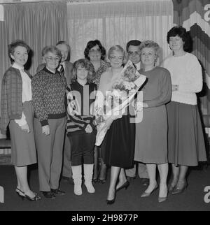 John Laing and Son Limited, Page Street, Mill Hill, Barnet, London, 30/03/1987. Mrs Joan Kirby posed holding a bouquet with a group of friends and colleagues during her retirement presentation at Mill Hill. Joan Kirby joined Laing in 1955 as a secretary for Mr Waldrum, who was in charge of personnel. She went on to work for various other individuals including John Renshaw. Joan joined Laing's Welfare Department in 1982 and retired from the Company in 1987, after 32 years of service. Stock Photo