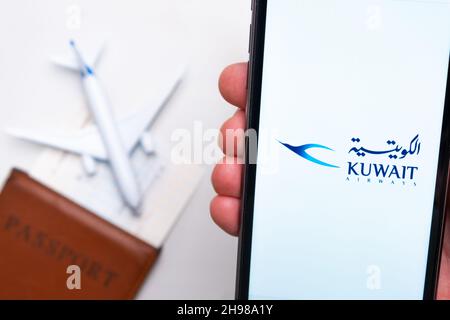 Kuwait Airwais application is displayed on the smartphone screen. There is a blurry plane, passport and boarding pass on the background. November 2021, San Francisco, USA Stock Photo