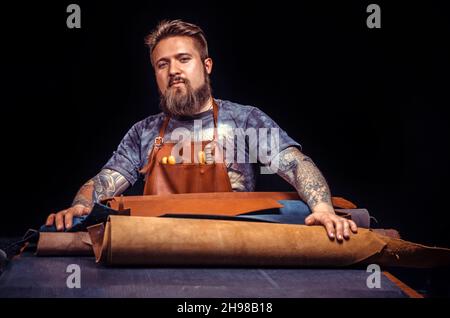 Skinner cutting out leather shapes for a new product Stock Photo