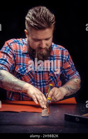 Leather Artisan creates a new leather product Stock Photo