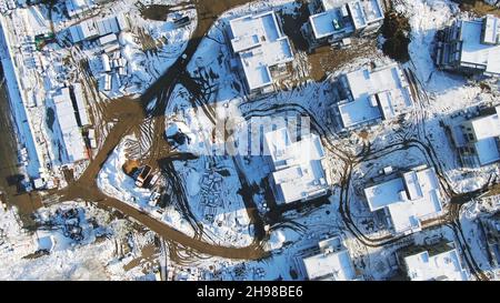 Aerial view of the winter cottages construction on the modern ski resort surrounded by forest. Sports and recreation concept Stock Photo