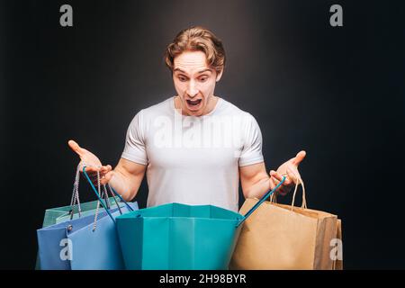 Surprised european man looking in opened shop bag Stock Photo