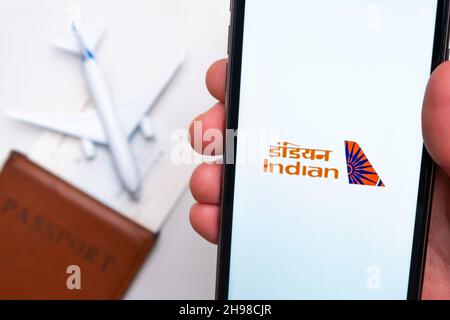 Indian Airline application is displayed on the smartphone screen. There is a blurry plane, passport and boarding pass on the background. November 2021, San Francisco, USA Stock Photo