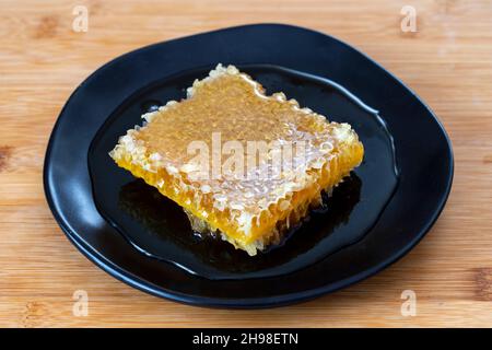 Organic honeycomb on wooden background. honey on the plate Stock Photo