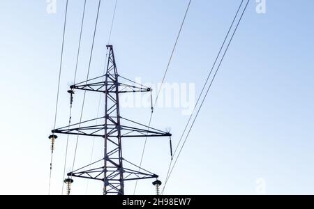 High voltage power lines, post or tower against the backdrop of a beautiful sky. Sequentially ordered high energy pylons. Stock Photo
