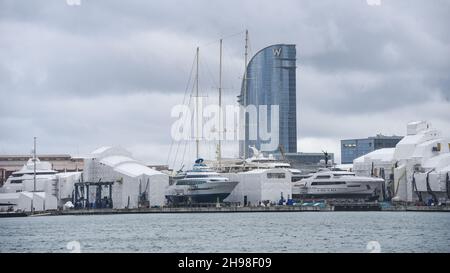 Barcelona, Spain - 24 Nov, 2021: Superyachts and boats in sailing in Barcelona shipyard with the hotel W in the background Stock Photo