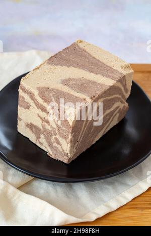 Halva with tahini and cocoa on wooden background. Local name kakaolu ve tahinli helva Stock Photo