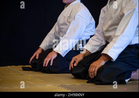 Athletes of Aikido (black belt) kneeling in Seiza position. Stock Photo