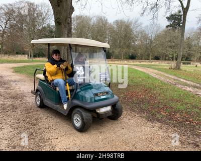 Golf buggy at Stowe School and landscape gardens Northamptonshire UK cart person sitting in vehicle electric National Trust ridding out outside park Stock Photo