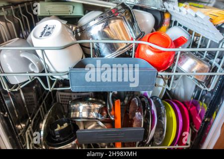 A fully loaded dishwasher with mixed plastic and earthenware Stock Photo