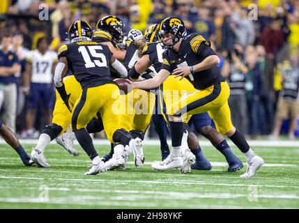 Indianapolis, Indiana, USA. 04th Dec, 2021. Iowa quarterback Spencer Petras (7) hands the ball off to Iowa running back Tyler Goodson (15) during NCAA Football game action between the Michigan Wolverines and the Iowa Hawkeyes at Lucas Oil Stadium in Indianapolis, Indiana. Michigan defeated Iowa 42-3. John Mersits/CSM/Alamy Live News Stock Photo