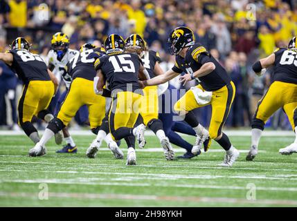 Indianapolis, Indiana, USA. 04th Dec, 2021. Iowa quarterback Spencer Petras (7) hands the ball off to Iowa running back Tyler Goodson (15) during NCAA Football game action between the Michigan Wolverines and the Iowa Hawkeyes at Lucas Oil Stadium in Indianapolis, Indiana. Michigan defeated Iowa 42-3. John Mersits/CSM/Alamy Live News Stock Photo