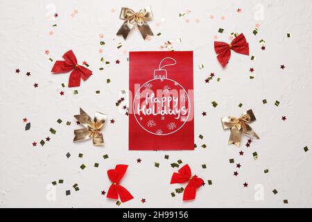 Greeting card with text HAPPY HOLIDAYS and Christmas decor on light background Stock Photo
