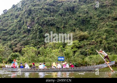 Tourist on Perfume Pagoda trip making their way to famous caves and temples in boats along Yen Vy river in North Vietnam Stock Photo