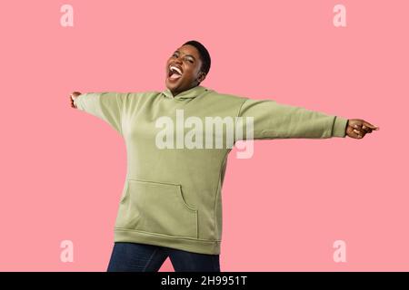 Cheerful Overweight African American Woman Shouting Spreading Hands, Pink Background Stock Photo