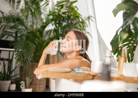 Cute young woman having fun, playing with soap bubbles while bathing at tropical spa resort Stock Photo