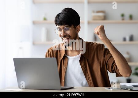 Emotional indian man project manager celebrating success Stock Photo