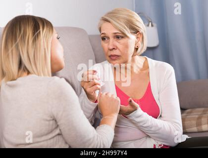 daughter comforts a sad mother Stock Photo