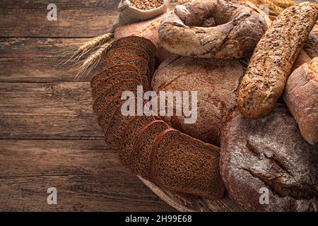 Freshly baked rye and wheat bread on a wooden table. Side view, copy space. Stock Photo