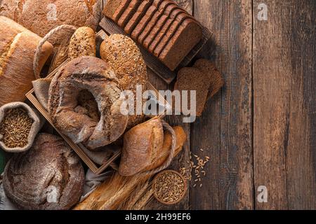 Fresh, rye and wheat bread on a brown, wooden background. Bakery products. Stock Photo
