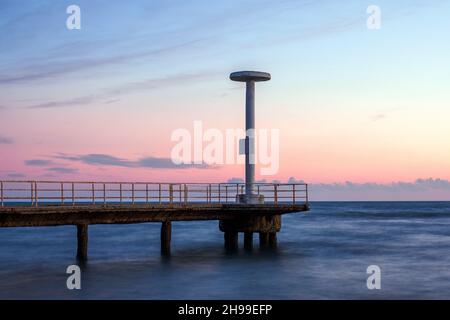 Pier of the Plinius beach resort in Ostia Lido on sunset - Rome, Italy Stock Photo