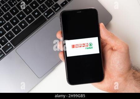 Spar Market mobile application of supermarkets and grocery chains is opened in a smartphone. Buying groceries online. A man uses a food delivery service in smartphone app November 2021, San Francisco, USA Stock Photo