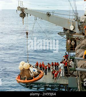 Crew men aboard the USS Iwo Jima, prime recovery ship for the Apollo 13 mission, hoist the Command Module (CM) aboard ship. The Apollo 13 crew men, astronauts James A. Lovell Jr., John L. Swigert Jr. and Fred W. Haise Jr., were already aboard the Iwo Jima when this photograph was taken. The CM, with the three tired crew men aboard, splashed down at 12:07:44 p.m. (CST), April 17, 1970, only about four miles from the recovery vessel in the South Pacific Ocean. Stock Photo