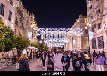 Seville, Spain - December 22,2020: Unidentified People walking around Seville Cathedral of Saint Mary of the See at christmas time. People wearing pro Stock Photo