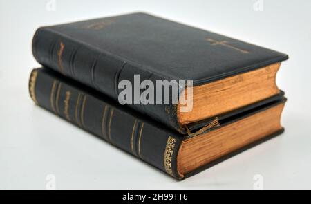 Two antique hymnals from 1910 and 1914 in a stack. The edges are finished with real gold. Isolated on a white background. Stock Photo