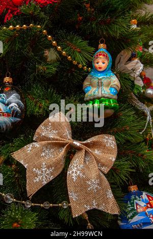 Various Christmas decorations are hung on the branches of the Christmas tree. Stock Photo
